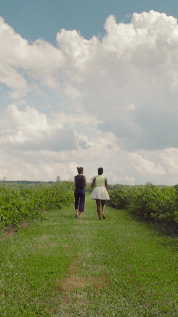 Oneika is walking with Anne in a blackcurrant field at Cassis Monna & Filles