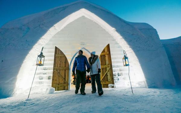Un couple devant l'Hôtel de Glace le soir
