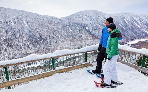 A couple snowshoes in the winter on the Les Loups trail in Jacques-Cartier National Park.