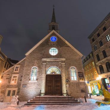 The Notre-Dame-des-Victoires church, illuminated in the evening, at Place-Royale, in the Petit-Champlain district, in winter.