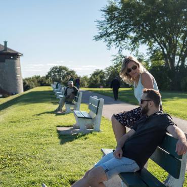 Couple sitting outside on a bench, near Martello Tower 1, on the Plains of Abraham.